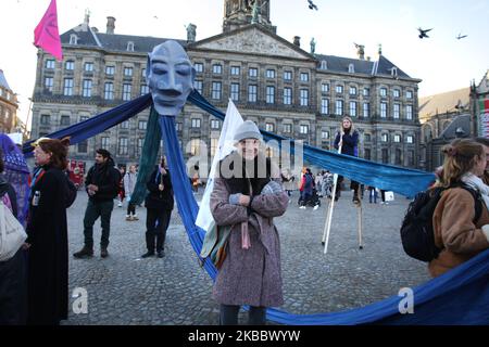 Gli attivisti della ribellione di estinzione si esibiscono durante la ribellione del Black Friday in Piazza Dam il 29 novembre 2019 ad Amsterdam, nei Paesi Bassi. I manifestanti chiedono l'attuale sistema dei consumi eccessivi, una sfilata di moda con venti modelli che indossano costumi con materiali riciclabili legati alla crisi climatica. L'industria della moda è destinata a consumare un quarto del budget mondiale di carbonio entro il 2050 nella produzione di abbigliamento. (Foto di Paulo Amorim/NurPhoto) Foto Stock