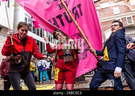 I membri dell'organizzazione ambientale Extension Rebellion protestano di fronte alla sede del partito conservatore a Londra, Inghilterra, il 6 dicembre 2019. L'organizzazione organizza la cosiddetta operazione Big Bird, dove i manifestanti marciano con una statua di un uccello che nasconde la sua testa in sabbia per illustrare un atteggiamento dei politici verso l'emergenza ambientale. L’organizzazione protesta per esercitare pressioni sui politici prima delle elezioni generali nel Regno Unito. (Foto di Dominika Zarzycka/NurPhoto) Foto Stock