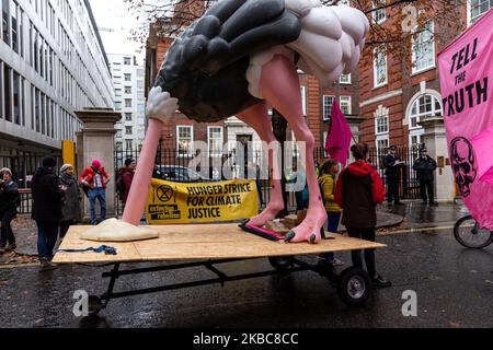 I membri dell'organizzazione ambientale Extension Rebellion protestano di fronte alla sede del partito conservatore a Londra, Inghilterra, il 6 dicembre 2019. L'organizzazione organizza la cosiddetta operazione Big Bird, dove i manifestanti marciano con una statua di un uccello che nasconde la sua testa in sabbia per illustrare un atteggiamento dei politici verso l'emergenza ambientale. L’organizzazione protesta per esercitare pressioni sui politici prima delle elezioni generali nel Regno Unito. (Foto di Dominika Zarzycka/NurPhoto) Foto Stock