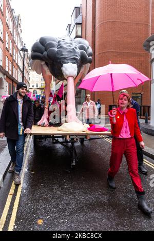 I membri dell'organizzazione ambientale Extension Rebellion protestano di fronte alla sede del partito conservatore a Londra, Inghilterra, il 6 dicembre 2019. L'organizzazione organizza la cosiddetta operazione Big Bird, dove i manifestanti marciano con una statua di un uccello che nasconde la sua testa in sabbia per illustrare un atteggiamento dei politici verso l'emergenza ambientale. L’organizzazione protesta per esercitare pressioni sui politici prima delle elezioni generali nel Regno Unito. (Foto di Dominika Zarzycka/NurPhoto) Foto Stock