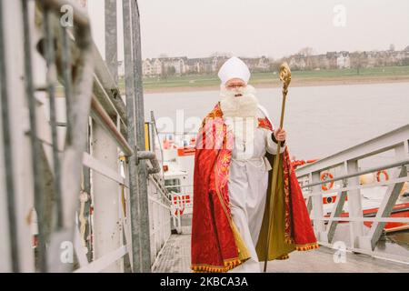 Nicholas arriva con la barca ''Alfons Frings'' sulla riva del fiume Reno Dusseldorf Dusseldorf ha una lunga tradizione di celebrazione della giornata di San Nicola inizia con la crociera sul Reno di San Nicola a Dusseldorf, Germania, il 6 dicembre 2019. Nicholas arriva sulle rive del Reno e viene accolto dai bambini degli asili. Poi accompagnerà con i suoi due asini Charly e Lilly e la giovane banda di ottone visiterà la chiesa della Basilica di San Lambetto e il municipio, dove i bambini riceveranno doni da Nicola. (Foto di Ying Tang/NurPhoto) Foto Stock