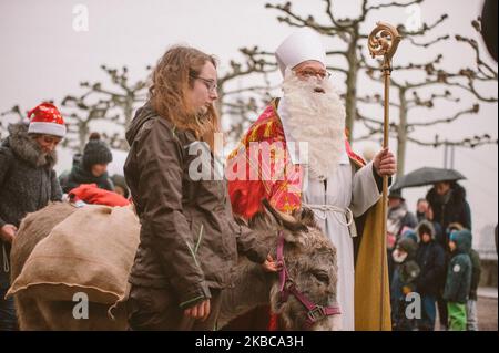 Nicholas accompagna con i suoi due asini ''Lili'' e ''Charly'' con borse di doni Dusseldorf ha una lunga tradizione di celebrazione di San Nicola giorno inizia con crociera sul Reno di San Nicola a Dusseldorf, Germania il 6 dicembre 2019. Nicholas arriva sulle rive del Reno e viene accolto dai bambini degli asili. Poi accompagnerà con i suoi due asini Charly e Lilly e la giovane banda di ottone visiterà la chiesa della Basilica di San Lambetto e il municipio, dove i bambini riceveranno doni da Nicola. (Foto di Ying Tang/NurPhoto) Foto Stock