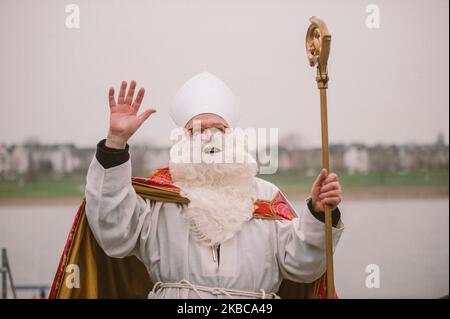 Nicholas arriva con la barca ''Alfons Frings'' sulla riva del fiume Reno Dusseldorf Dusseldorf ha una lunga tradizione di celebrazione della giornata di San Nicola inizia con la crociera sul Reno di San Nicola a Dusseldorf, Germania, il 6 dicembre 2019. Nicholas arriva sulle rive del Reno e viene accolto dai bambini degli asili. Poi accompagnerà con i suoi due asini Charly e Lilly e la giovane banda di ottone visiterà la chiesa della Basilica di San Lambetto e il municipio, dove i bambini riceveranno doni da Nicola. (Foto di Ying Tang/NurPhoto) Foto Stock