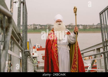 Nicholas arriva con la barca ''Alfons Frings'' sulla riva del fiume Reno Dusseldorf Dusseldorf ha una lunga tradizione di celebrazione della giornata di San Nicola inizia con la crociera sul Reno di San Nicola a Dusseldorf, Germania, il 6 dicembre 2019. Nicholas arriva sulle rive del Reno e viene accolto dai bambini degli asili. Poi accompagnerà con i suoi due asini Charly e Lilly e la giovane banda di ottone visiterà la chiesa della Basilica di San Lambetto e il municipio, dove i bambini riceveranno doni da Nicola. (Foto di Ying Tang/NurPhoto) Foto Stock