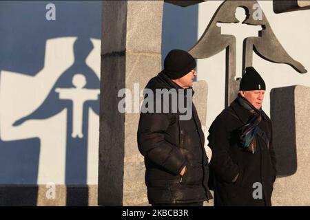 Two men walk past a monument to the victims of man-made famine in Soviet Ukraine in 1932 and 1933 called Holodomor in Kyiv, Ukraine, December 5, 2019. (Photo by Sergii Kharchenko/NurPhoto) Stock Photo