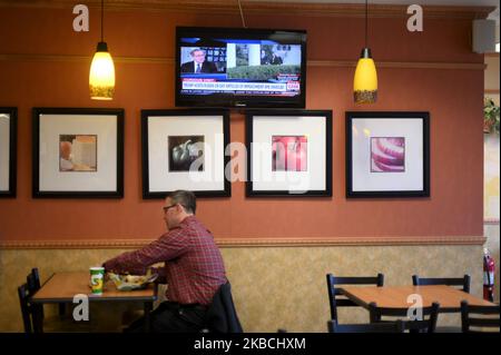 Un uomo mangia un panino con un televisore è acceso alla copertura CNN dell'impeachment di Trump, a Hershey, PA, il 10 dicembre 2019. Il presidente degli Stati Uniti Donald Trump e il vicepresidente Mike Pence tornano in Pennsylvania per un rally della campagna Keep America Great al Giant Center, a Hershey, Pennsylvania, il 10 dicembre 2019. (Foto di Bastiaan Slabbers/NurPhoto) Foto Stock
