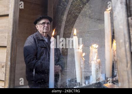 Un uomo osserva il santuario da piccoli altari dove i visitatori possono acquistare diversi tipi di candele e illuminarle in onore della vergine il 30 novembre 2019 a Lourdes, in Francia. Il Papa ferma l'attività dei miracoli a LourdesFrancisco interviene il santuario e invia un delegato per recuperare il lato spirituale del luogo, sepolto dal suo lato commerciale e turistico. Lourdes riceve due milioni e mezzo di visite all'anno. È un turismo che ha fede come pretesa e che ha trasformato un'intera valle che vive sui pellegrini. (Foto di Alvaro Fuente/NurPhoto) Foto Stock