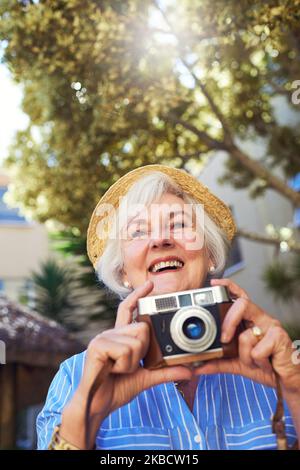 Scattandosi via ma godendo ogni momento. Una donna anziana che scatta le fotografie nel paese. Foto Stock