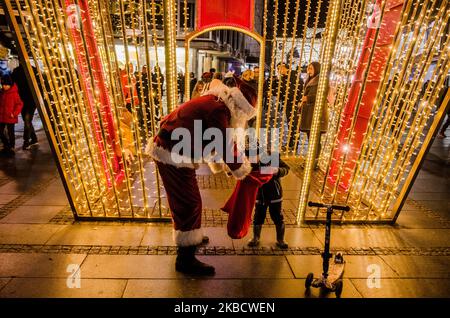 Babbo Natale è visto dà regali ai bambini nella strada pedonale principale di Belgrado, Serbia. La gente si vede godendo le decorazioni natalizie nella capitale serba di Belgrado, Serbia il 13 dicembre 2019 (Foto di Hristo Rusev/NurPhoto) Foto Stock