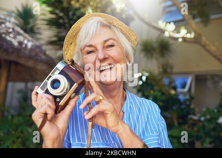 Non lasciate che il pensionamento vi scorra di catturare i momenti. Una donna anziana che fotografa a casa. Foto Stock