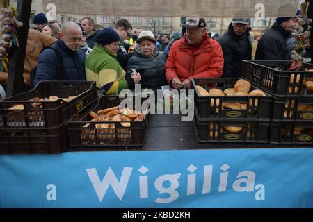 Persone in fila durante l'edizione 2019 di "Christmas Eve - Christmas Food Handout" per senzatetto e persone bisognose, un evento di beneficenza organizzato ogni anno nella piazza principale del mercato di Cracovia. Domenica 15 dicembre 2019, a Cracovia, Malopolskie Voivodato, Polonia. (Foto di Artur Widak/NurPhoto) Foto Stock