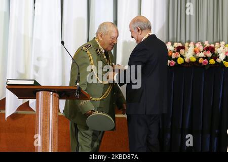 Il presidente algerino Abdelmajid Tebboune (R) bacia il capo delle forze armate, il tenente generale Ahmed GAID Salah (C), durante la cerimonia di giuramento ad Algeri (Algeria), 19 dicembre 2019. Tebboune è stato eletto con un mandato quinquennale nelle elezioni presidenziali del 12 dicembre la prima da quando l'ex presidente Abdelaziz Bouteflika si è dimesso nell'aprile 2019 (Foto di Billal Bensalem/NurPhoto) Foto Stock