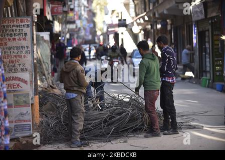 Nepal Electricity Authority (NEA) lavoratori che rimuovono i fili penzolanti, cavi da tutta la zona intorno al Thamel nucleo, Kathmandu, Nepal Domenica, 22 dicembre 2019. NEA ha iniziato a lavorare per mettere le linee elettriche nel sottosuolo. (Foto di Narayan Maharjan/NurPhoto) Foto Stock