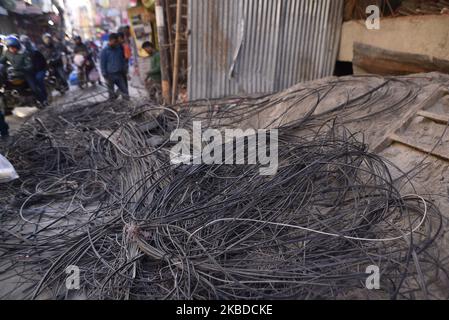 Nepal Electricity Authority (NEA) lavoratori che rimuovono i fili penzolanti, cavi da tutta la zona intorno al Thamel nucleo, Kathmandu, Nepal Domenica, 22 dicembre 2019. NEA ha iniziato a lavorare per mettere le linee elettriche nel sottosuolo. (Foto di Narayan Maharjan/NurPhoto) Foto Stock