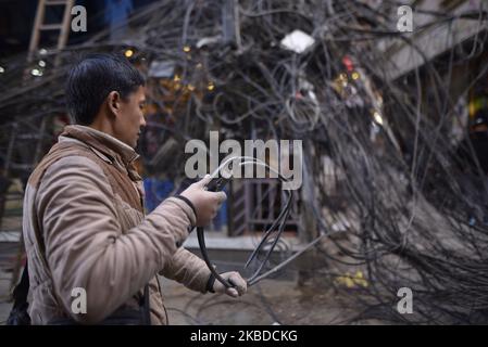 Nepal Electricity Authority (NEA) lavoratori che rimuovono i fili penzolanti, cavi da tutta la zona intorno al Thamel nucleo, Kathmandu, Nepal Domenica, 22 dicembre 2019. NEA ha iniziato a lavorare per mettere le linee elettriche nel sottosuolo. (Foto di Narayan Maharjan/NurPhoto) Foto Stock