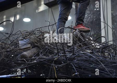 Nepal Electricity Authority (NEA) lavoratori che rimuovono i fili penzolanti, cavi da tutta la zona intorno al Thamel nucleo, Kathmandu, Nepal Domenica, 22 dicembre 2019. NEA ha iniziato a lavorare per mettere le linee elettriche nel sottosuolo. (Foto di Narayan Maharjan/NurPhoto) Foto Stock