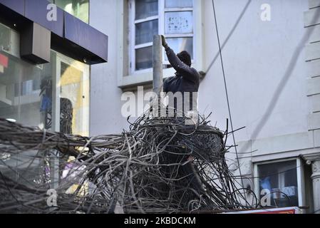 Nepal Electricity Authority (NEA) lavoratori che rimuovono i fili penzolanti, cavi da tutta la zona intorno al Thamel nucleo, Kathmandu, Nepal Domenica, 22 dicembre 2019. NEA ha iniziato a lavorare per mettere le linee elettriche nel sottosuolo. (Foto di Narayan Maharjan/NurPhoto) Foto Stock