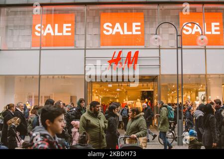 Crowd of people walk pass by the H&M in the city center of Cologne, Germany, on December 26, 2019. (Photo by Ying Tang/NurPhoto) Stock Photo