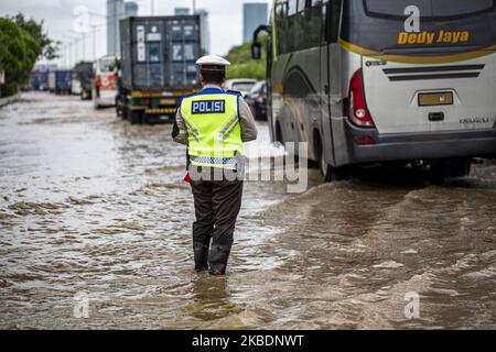 Jakarta, Indonesia, 02 January 2019 : Police man taking care of traffic at kebon jeruk-west jakarta toll road. Second day after heavy rain hit Jakarta and surrounding area, floods still covered several area, total arroun 19 people died from the flood. (Photo by Donal Husni/NurPhoto) Stock Photo