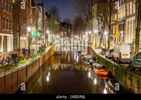 I canali di Amsterdam come Amstel, con la tipica architettura tradizionale olandese, ospitano case illuminate e case galleggianti la sera e la notte con splendidi riflessi sull'acqua e luci della città, Olanda, Olanda. Amsterdam è un centro finanziario, ma anche una delle città più visitate d'Europa, che attrae milioni di turisti in tutto il mondo, con il turismo che svolge un ruolo significativo nell'economia locale nonostante le voci che si oppongono a questo sviluppo turistico. (Foto di Nicolas Economou/NurPhoto) Foto Stock