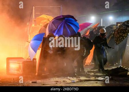 I manifestanti utilizzano uno scudo improvvisato per spingere verso la linea di controllo della polizia il 12 novembre 2019. Battaglia del ponte numero due nell'Università cinese di Hong Kong. La polizia che entra all'università e gli studenti spingono indietro la polizia. (Foto di Kwan Wong/NurPhoto) Foto Stock