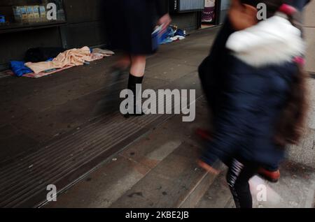 La gente passa davanti ai letti e agli effetti personali delle traversine fuori dalla stazione della metropolitana di Westminster a Londra, Inghilterra, il 7 gennaio 2020. I dati della Greater London Authority rivelano un numero crescente di senzatetto in città, con i migranti dell’Europa orientale il gruppo in più rapida crescita. Questi costituiscono quasi la metà delle traversine a Westminster, il quartiere con il problema più acuto. (Foto di David Cliff/NurPhoto) Foto Stock