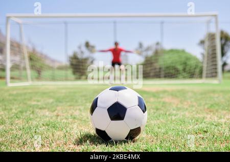 Pallone da calcio, campo da calcio e portiere pronti per la difesa per fermare i gol per la partita di calcio di Punizione sul campo da calcio, campo da prato e stadio sportivo Foto Stock