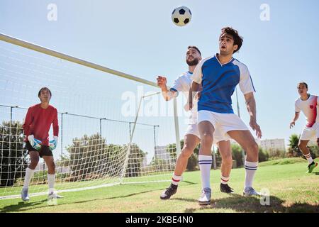 Calcio, sport e gioco di squadra in un campo all'aperto per l'esercizio fisico, l'allenamento e l'allenamento. Lavoro di squadra, calcio e atleti sani che praticano con Foto Stock
