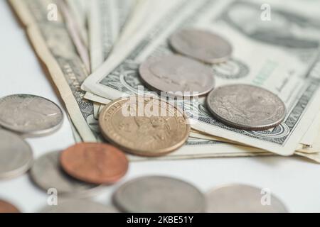 Foto Illustrazione di moneta americana, valuta USD, monete in dollari e centesimi che si trovano sulle banconote, banconote in dollari su una superficie bianca il 8 gennaio 2020 ad Amsterdam, Paesi Bassi. (Foto di Nicolas Economou/NurPhoto) Foto Stock