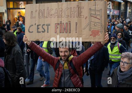 A protester holds a placard reading 'This is the end for the oligarchy'. Yellow Vests protesters demonstrated for more than 60 weeks in a row across France. Several thousands protesters took to the streets of Toulouse. They also protested against the Macron's planned reform on retirement. But the peaceful protest came to a sudden end as riot police and fired water cannon and fired tear gas canisters. Toulouse. France. January 11th 2020. (Photo by Alain Pitton/NurPhoto) Stock Photo