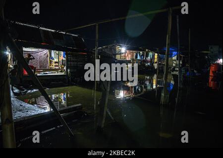 I residenti si spostano nelle loro case che sono allagate da inondazioni di marea o maree marine nel villaggio di Tompe, Distretto di Sirenja, Regency di Dongala, Provincia Centrale di Sulawesi, Indonesia il 12 gennaio 2020. Le inondazioni di marea che entrano nelle aree residenziali si verificano ogni 15 giorni a causa di una diminuzione della superficie terrestre fino a due metri a causa del terremoto di magnitudine 7,4 centrato nel villaggio il 28 settembre 2018 allora. I residenti locali sono costretti a fuggire in alto e tornare alle loro case dopo che l'acqua è diminuita. Questa condizione si è verificata da un anno e mezzo fa fino ad ora. (Foto di Basr Foto Stock