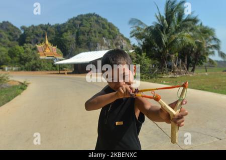 Un ragazzo locale che gioca con un tiro a schiaffo vicino alla zona di Kampong Trach Mountain. Martedì 7 gennaio 2020, KEP City, Cambogia. (Foto di Artur Widak/NurPhoto) Foto Stock