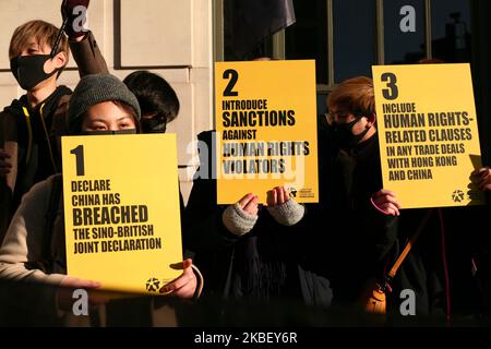 Gli attivisti che indossano maschere facciali si radunano in solidarietà con il movimento pro-democrazia di Hong Kong e in protesta per il trattamento della Cina nei confronti dei suoi popoli tibetano e uiguro in occasione di una manifestazione per tutte e tre le cause al di fuori dell'ambasciata cinese a Londra, in Inghilterra, il 19 gennaio 2020. Nel suo recente "World Report 2020", la scorsa settimana l'ONG di ricerca e di difesa di New York Human Rights Watch ha individuato una "repressione deepening" da parte delle autorità cinesi nel corso del 2019, tra cui le libertà religiose in Tibet e nella patria uigura dello Xinjiang, come la caratteristica distintiva di quello che è stato il 70th° anniversario Foto Stock