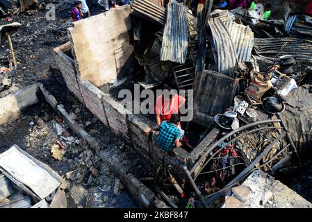 Gli abitanti del Bangladesh hanno visto cercare i loro beni familiari dopo un devastante incendio scoppiato a Chalantika slum ieri sera a Dhaka, in Bangladesh, il 24 gennaio 2020. Almeno 200 shanties sono stati eviscerati come il fuoco devastante che scoppiò a Chalantika slum nel Mirpur di Dhaka. (Foto di Mamunur Rashid/NurPhoto) Foto Stock
