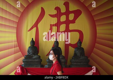 Una donna cammina di fronte ad una statua buddista durante le celebrazioni lunari del Capodanno al Wat Mangkon Kamalawat a Chinatown, Bangkok , Thailandia, 24 gennaio 2020. (Foto di Anusak Laowilas/NurPhoto) Foto Stock