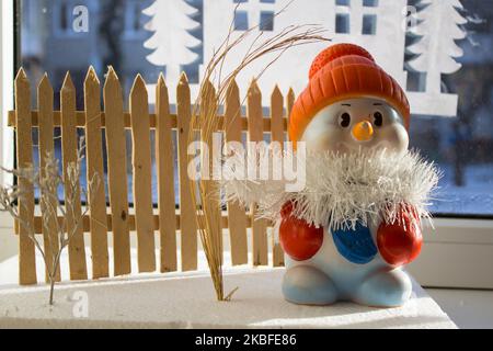 sulla finestra si trova un giocattolo da palla di neve nel cappuccio Foto Stock