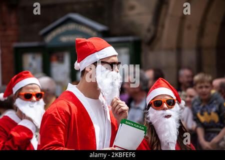 Newcastle-Under-Lyme, Staffordshire-Regno Unito 14 aprile 2022 uomini vestiti come Babbo Natale in occhiali da sole scuro in preparazione per una corsa di beneficenza divertente Foto Stock