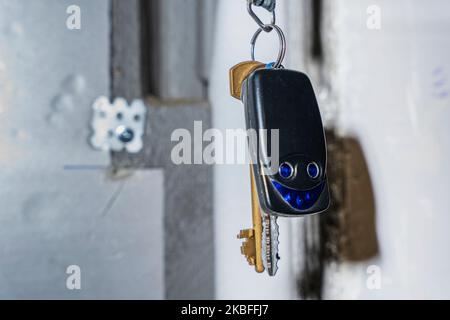 un mazzo di chiavi e un portachiavi con tasti appendono su un gancio Foto Stock