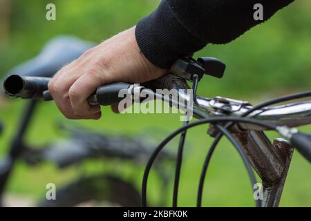 Mani dell'uomo che tengono la maniglia di un ciclo Foto Stock