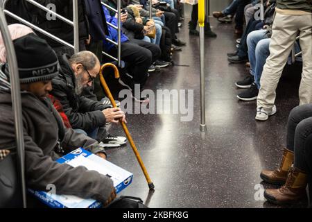 Vita quotidiana a New York City, New York City, della metropolitana che si trova il 23 gennaio 2020. All'interno di un affollato treno durante le ore di punta, le persone vagone carrozza sono in giro per fare un viaggio in auto della metropolitana per lavorare o studiare in un treno della città di MTA. La maggior parte delle persone sono concentrate sui loro telefoni cellulari. La metropolitana di New York Manhattan è una delle più antiche del mondo. New York, USA (Foto di Nicolas Economou/NurPhoto) Foto Stock