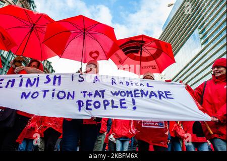 Un gruppo di donne tiene un cartello femminista mentre tiene ombrelli rossi, durante la manifestazione nazionale per una migliore sicurezza sociale, che si terrà a Bruxelles il 28 gennaio 2020. (Foto di Romy Arroyo Fernandez/NurPhoto) Foto Stock