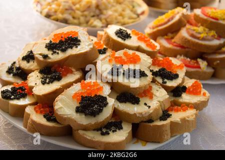 sandwich con caviale nero e rosso sul tavolo Foto Stock