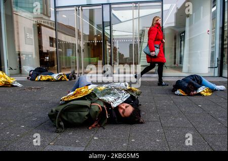 Un gruppo di attivisti della XR finge di essere un falso morto mentre una donna passa, durante la terza rivolta di estinzione muore in azione, a Rotterdam il 3rd febbraio 2020. (Foto di Romy Arroyo Fernandez/NurPhoto) Foto Stock