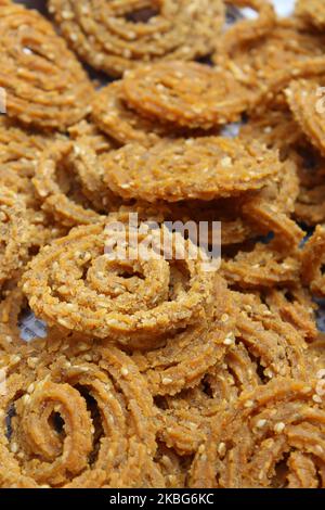 Chakali crudi in piatto. Indiano tradizionale tè tempo snack Chakli, uno snack fritto profondo, è noto come Chakali, Murukku, Muruku, Murkoo, Chakri. Foto Stock