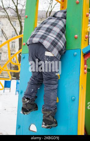 Bambini arrampicata scivolo inverno nel parco Foto Stock