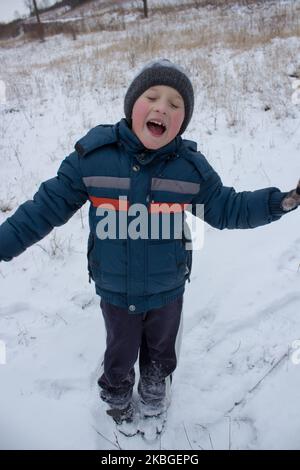 bambino che si diverse in vacanza d'inverno, ragazzo che urla d'inverno Foto Stock