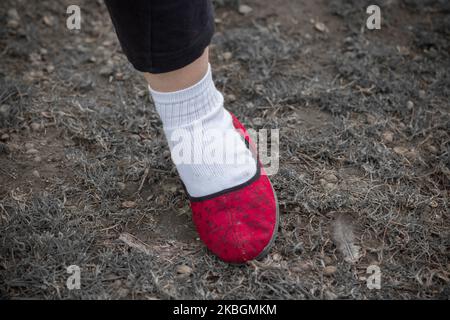 pantofole rosse ai piedi e calzini bianchi vestiti Foto Stock