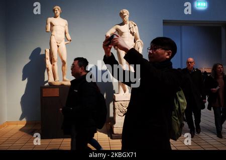 Visitors walk past statues in the Greek and Roman section of the British Museum in London, England, on February 13, 2020. The museum, one of London's top tourist attractions, is rarely far from controversy, from its long-running refusal to comply with Greek wishes for repatriation of the Parthenon Sculptures (otherwise known as the Parthenon or Elgin Marbles), to other debates on restitution over artifacts including the Rosetta Stone (taken from Egypt) and Benin bronzes (taken from what is now Nigeria), to more recent pressure from climate activists over the institution's sponsorship ties to o Stock Photo