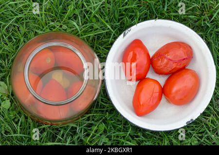 Pomodori in scatola sull'erba con le rive e piatto vista dall'alto Foto Stock
