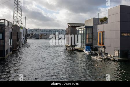 Case galleggianti ad Amsterdam visto il 17 febbraio 2020. I Paesi Bassi sono un paese protetto dalle dighe, dove le persone vivono su tumuli di origine umana che li innalzano sopra il livello del mare, e nell'acqua su case galleggianti. Le case galleggianti e gli hotel galleggianti possono essere visti lungo i canali di Amsterdam e di altre città. Le case galleggianti sono state suggerite come una soluzione vitale, ecofriendly e sostenibile alle necessità di alloggiamento dell'Olanda moderna. Un esempio di case galleggianti ad Amsterdam è lo Steigereiland, la prima isola costruita parte dell'arcipelago di IJburg, nella parte orientale della città. Quest'isola wa Foto Stock